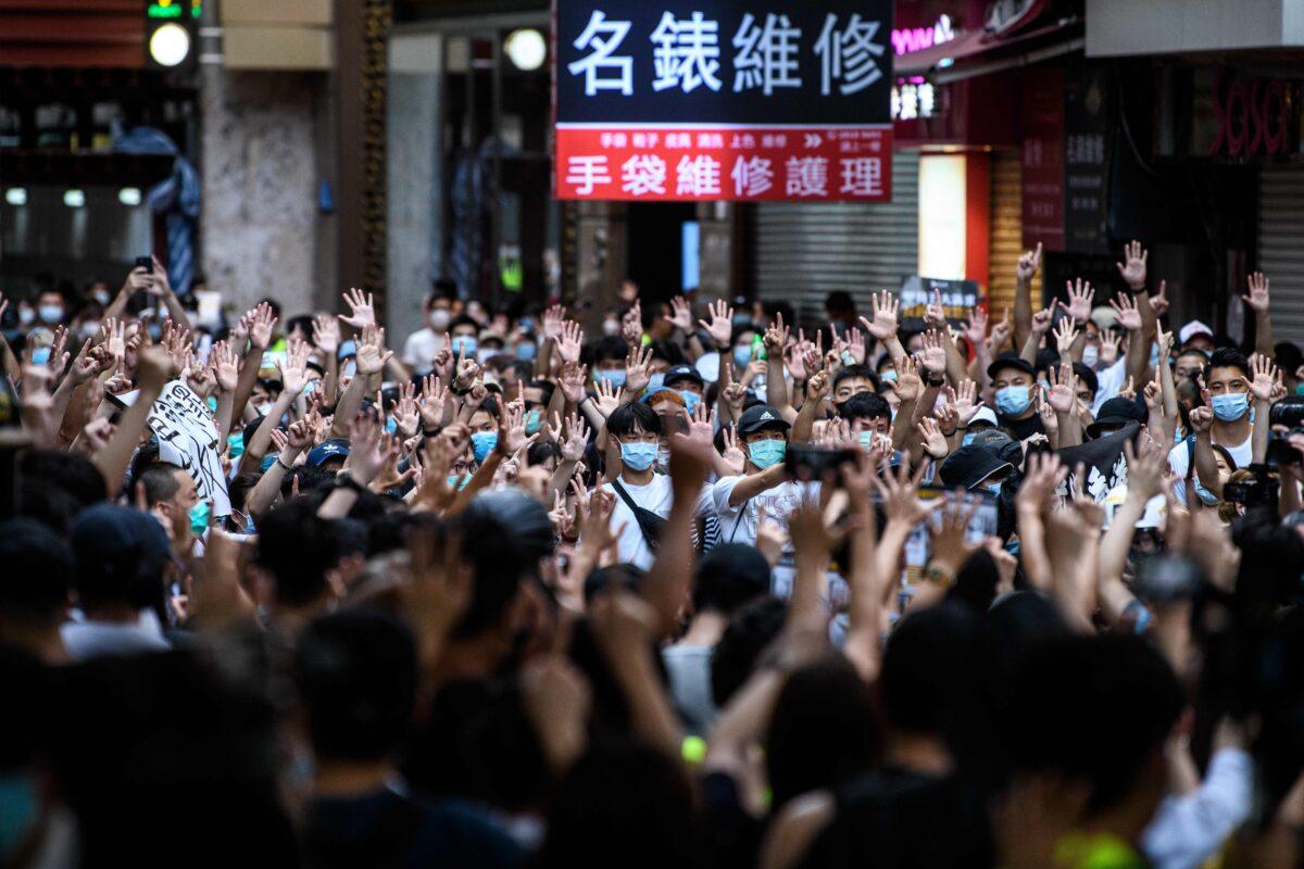 Protesters chant slogans and gesture during a rally against a new national security law in Hong Kong on July 1, 2020. (Anthony Wallace/AFP via Getty Images)
