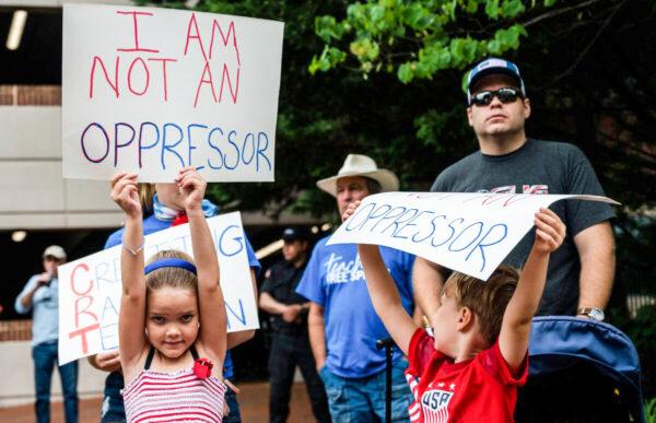 Children hold up signs during a rally against critical race theory being taught in schools at the Loudoun County Government Center in Leesburg, Va., on June 12, 2021. (Andrew Caballero-Reynolds/AFP via Getty Images)