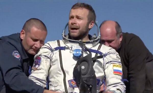 In this photo taken from video footage released by Roscosmos Space Agency, Russian space agency rescue team members help film director Klim Shipenko out from the capsule shortly after the landing of the Russian Soyuz MS-18 space capsule, southeast of the Kazakh town of Zhezkazgan, Kazakhstan, on Oct. 17, 2021. (Roscosmos Space Agency via AP)
