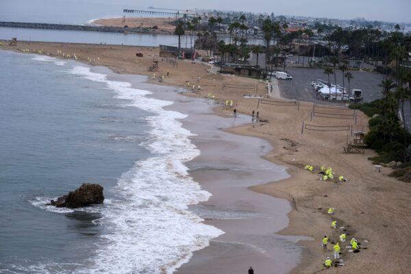 Workers in protective suits clean the contaminated beach in Corona Del Mar after an oil spill in Newport Beach, Calif., on Oct. 7, 2021. (Ringo H.W. Chiu/AP Photo)