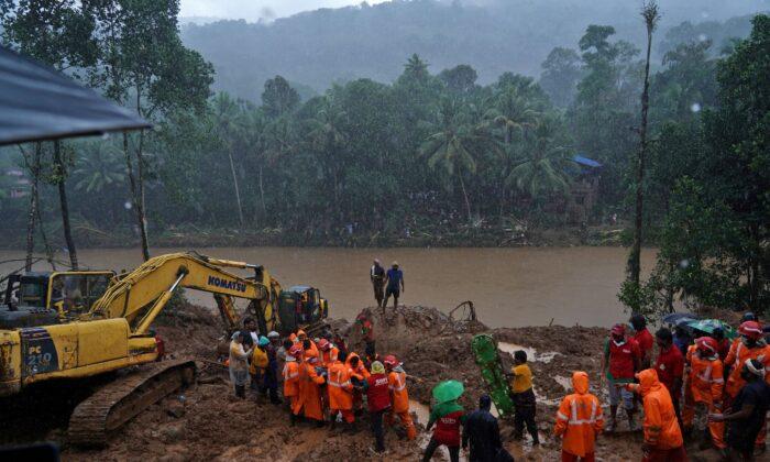 Rescue workers carry the body of a victim after recovering it from the debris of a residential house following a landslide caused by heavy rainfall at Kokkayar village in Idukki district in the southern state of Kerala, India, on Oct. 17, 2021. (Stringer/Reuters)