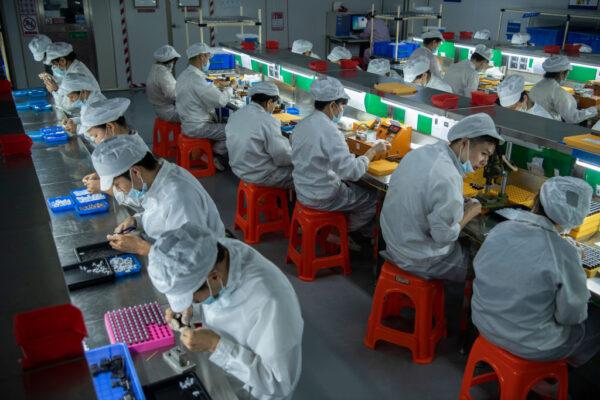 Workers make pods for the e-cigarette company Mystlabs on the production line at First Union, one of China's leading manufacturers of vaping products in Shenzhen city, Guangdong province, China, on Sept. 25, 2019. (Kevin Frayer/Getty Images)