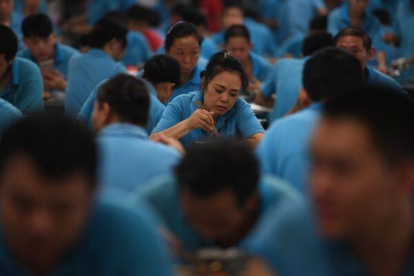 Workers eat lunch in the cafeteria of a shoe factory in Dongguan, in China's southern Guangdong province on September 14, 2016. (Greg Baker/AFP via Getty Images)