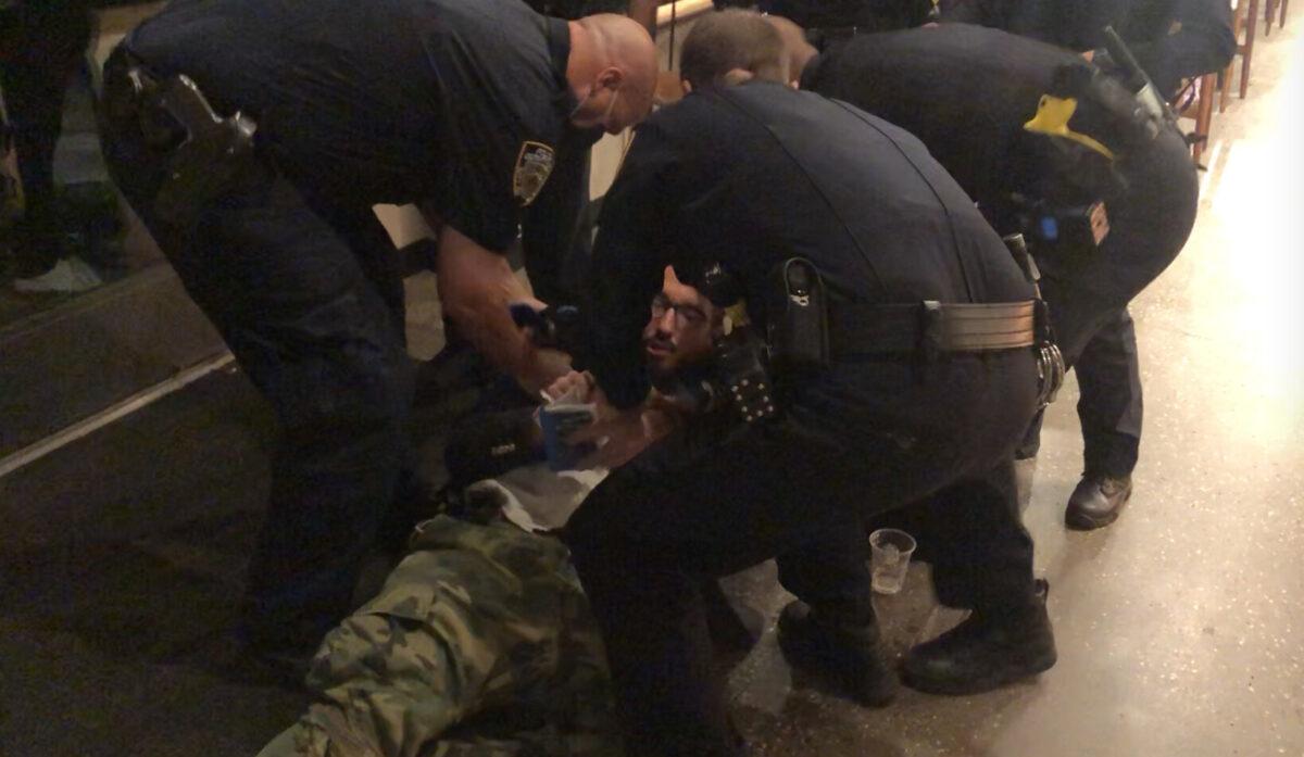 Michael Molinaro reading the 14th Amendment while he is being arrested by NYPD in lower Manhattan, New York, on Oct. 19, 2021. (Arian Pasdar/NTD News)