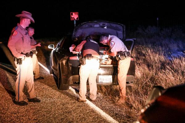 Kinney County Sheriffs deputies search a vehicle after arresting a U.S. citizen smuggler who was transporting four illegal aliens to San Antonio, in Kinney County, Texas, on Oct. 20, 2021. (Charlotte Cuthbertson/The Epoch Times)