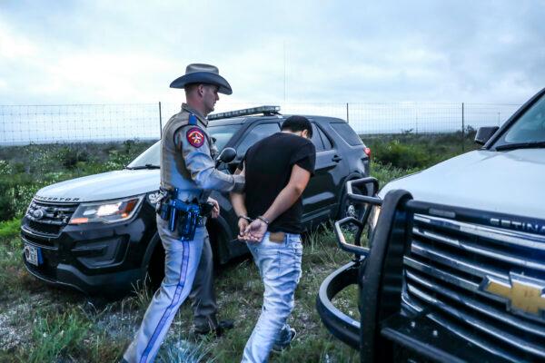 Texas State Troopers arrest two U.S. citizens who were transporting three illegal aliens to San Antonio, in Kinney County, Texas, on Oct. 20, 2021. (Charlotte Cuthbertson/The Epoch Times)