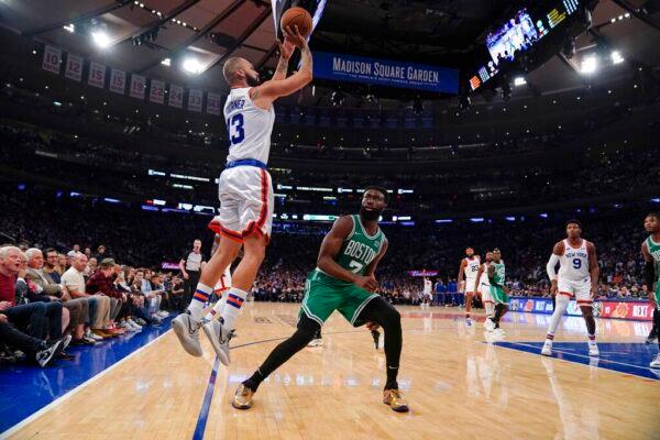 New York Knicks' Evan Fournier (13) shoots over Boston Celtics' Jaylen Brown (7) during the first half of an NBA basketball game in New York on Oct. 20, 2021. (Frank Franklin II/AP Photo)