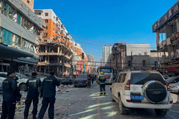 In this photo released by Xinhua News Agency, policemen and firefighters walk through damaged buildings following an explosion in Shenyang in northeastern China's Liaoning Province on Oct. 21, 2021. (Cai Xiangxin/Xinhua via AP)