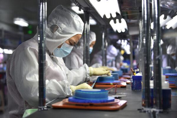 Workers produce adhesive tapes for flexible printed circuits at a factory in Yancheng in China's eastern Jiangsu Province on Sept.15, 2021. (STR/AFP via Getty Images)