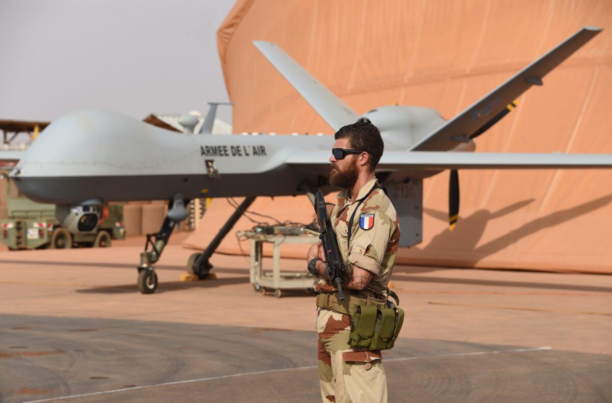 A French soldier involved in the regional anti-insurgent Operation Barkhane stands guard next to a Reaper drone at the French military airbase in Niamey, Niger, on March 14, 2016. (Pascal Guyot/AFP via Getty Images)