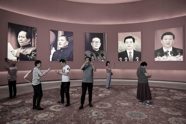 A group of people take pictures in front of portraits of CCP leaders (L to R) Mao Zedong, Deng Xiaoping, Jiang Zemin, Hu Jintao, and Xi Jinping at an exhibition marking the country's achievements over the past 70 years, ahead of the 70th anniversary of the founding of communist China, in Beijing, on Sept. 26, 2019. (Wang Zhao/AFP via Getty Images)