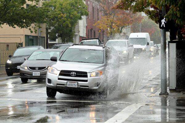 A car makes a big splash driving over a puddle on Third Street in San Rafael, Calif., on Oct. 21, 2021. (Sherry LaVars/Marin Independent Journal via AP)