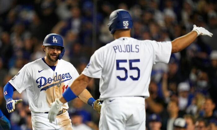 AJ Pollock of the Los Angeles Dodgers is congratulated by Albert Pujols after hitting a three-run home run during the eighth inning against the Atlanta Braves in Game 5 of baseball's National League Championship Series in Los Angeles, Calif., on Thursday, Oct. 21, 2021. (Jae C. Hong/AP Photo)