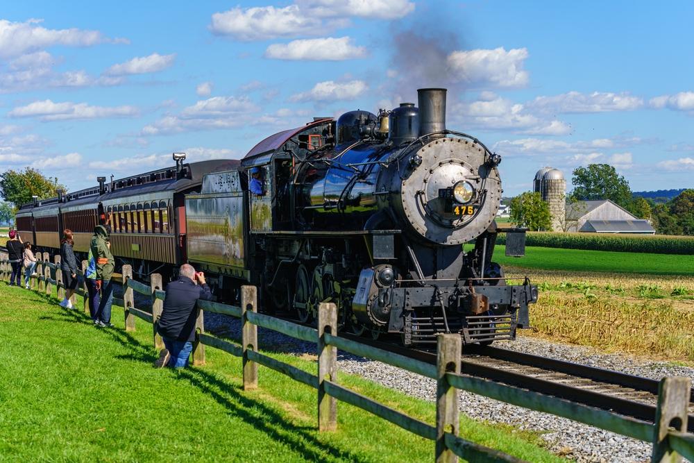 Visitors and tourists snap photos of a steam locomotive as it chugs to the station in rural Lancaster County. (George Sheldon/Shutterstock)