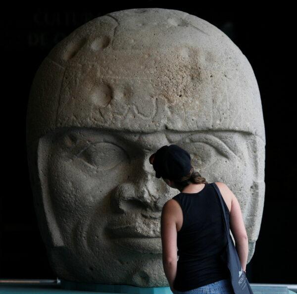 A visitor looks at an Olmec colossal head during the preview of "Colossal masterworks of the Olmec world" exhibition at the Anthropology Museum in Mexico City, on July 20, 2011. (Carlos Jasso/Reuters)