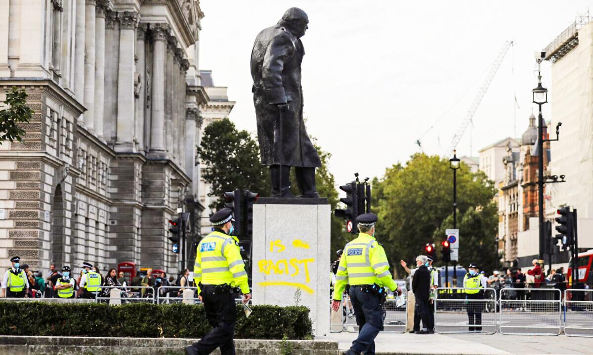 Police officers walk by the defaced statue of Winston Churchill, in London, on Sept. 10, 2020. (Simon Dawson/Reuters)