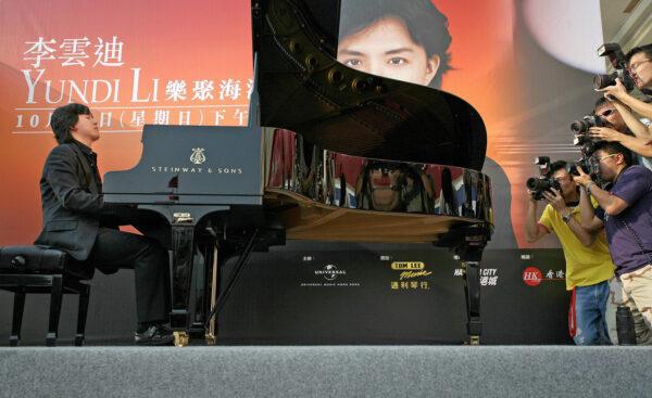 World-class pianist Li Yundi from mainland China is photographed by journalists (R) in his first outdoor performance along the harbor front in Hong Kong on Oct. 29, 2006. (Samantha Sin/AFP via Getty Images)