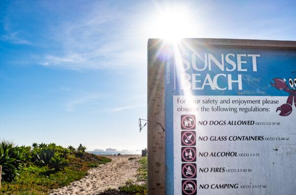 A sign informs beachgoers of the rules on Sunset Beach in Huntington Beach, Calif., on Oct. 24, 2021. (John Fredricks/The Epoch Times)