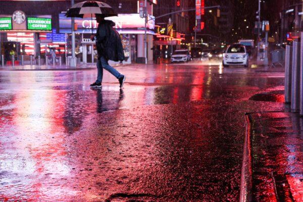 A person walks through Times Square during a Nor'easter in New York on Oct. 26, 2021. (Caitlin Ochs/Reuters)