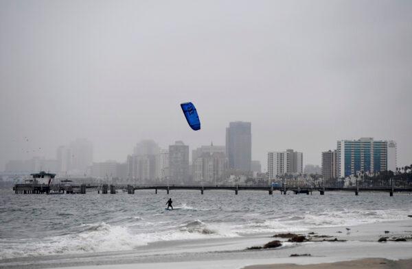 A wind surfer surfs in the rain in Long Beach, Calif., on Oct. 25, 2021. (Brittany Murray/The Orange County Register via AP)