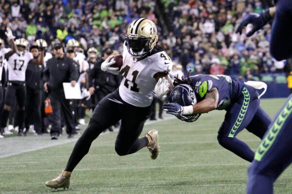 New Orleans Saints' Alvin Kamara runs for a touchdown after a pass reception as Seattle Seahawks' Ryan Neal defends during the first half of an NFL football game, in Seattle, Wash., on Oct. 25, 2021. (John Froschauer/AP Photo)