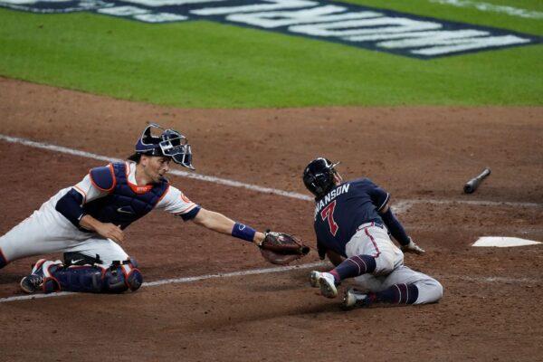Atlanta Braves' Dansby Swanson scores past Houston Astros catcher Jason Castro on a sacrifice fly during the eighth inning of Game 1 in baseball's World Series between the Houston Astros and the Atlanta Braves, in Houston, Texas, on Oct. 26, 2021. (Eric Gay/AP Photo)