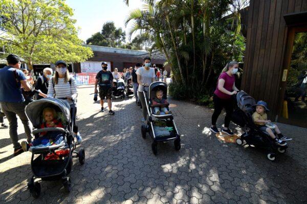 Families make their way to enter Taronga Zoo in Sydney, Australia, on Oct. 18, 2021, as the zoo reopened its doors to the vaccinated visitors after the lifting of Sydney’s lockdown restrictions. (Saeed Khan/AFP)