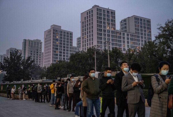 People line up for a PCR test for COVID-19 outside a private testing site in Beijing, China, on Oct. 25, 2021. (Kevin Frayer/Getty Images)