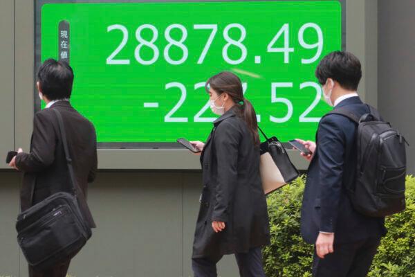 People walk by an electronic stock board of a securities firm in Tokyo, Japan on Oct. 27, 2021. (Koji Sasahara/AP Photo)