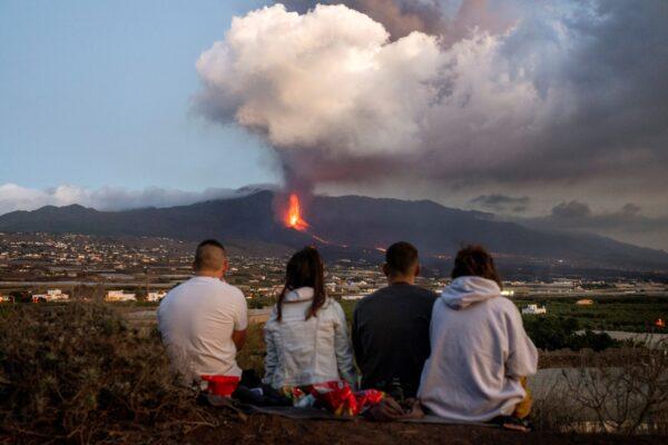 Residents watch as lava flows from a volcano as it continues to erupt on the Canary island of La Palma, Spain, on Oct. 26, 2021. (Emilio Morenatti/AP Photo)