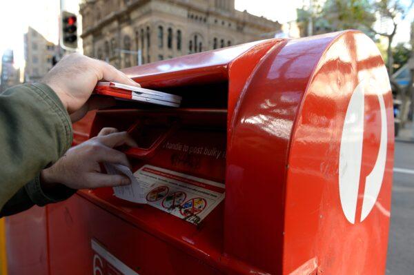 A man posting mail at an Australia Post postbox in Sydney, Australia, Sept. 2, 2013. (AAP Image/Dan Himbrechts)