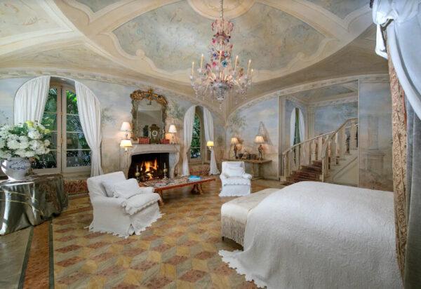 The master bedroom’s vaulted ceiling is adorned with hand-painted frescoes that give the space an air of opulence with a hint of the Italian Renaissance. (Jim Bartsch/Jade Mills)