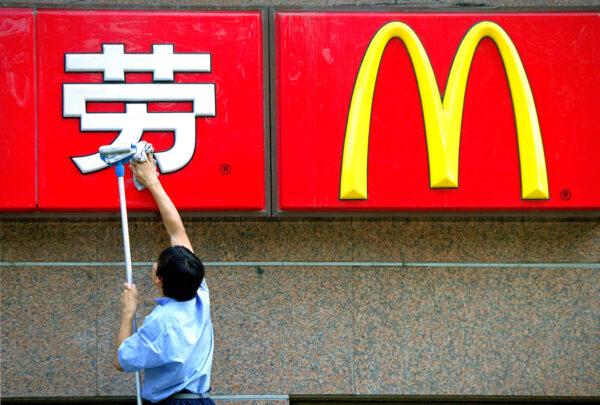 A Chinese worker cleans the sign in front of a McDonald's restaurant in Beijing on Aug. 29, 2001. (Kevin Lee/Getty Images)
