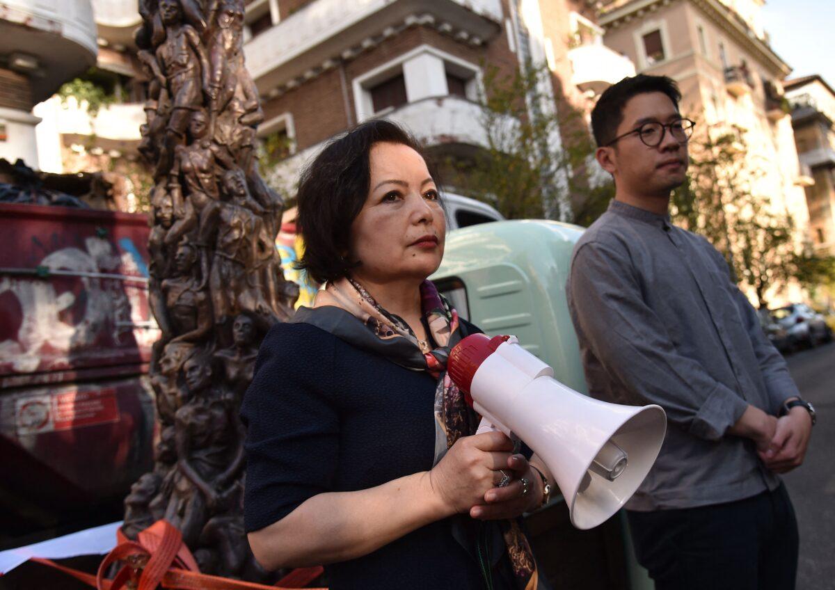 Uyghur human rights activist Rahima Mahmut (L) and Hong Kong activist, politician, and chairman of the Demosisto political party Nathan Law, stand by a replica of the "Pillar of Shame," a statue commemorating the 1989 Tiananmen Square massacre, during a demonstration outside the Chinese embassy in Rome, against the "Chinese government's dismantling of Hong Kong's democracy and autonomy" ahead of the G-20 World Leaders Summit in Rome, on Oct. 27, 2021. (Andreas Solaro/AFP via Getty Images)