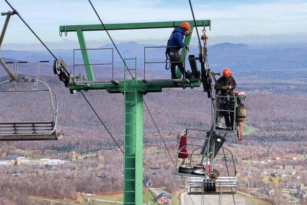 Workers do routine seasonal maintenance to a chairlift at Jay Peak Resort, in Jay, Vt., on Oct. 27, 2021. (Lisa Rathke/AP Photo)