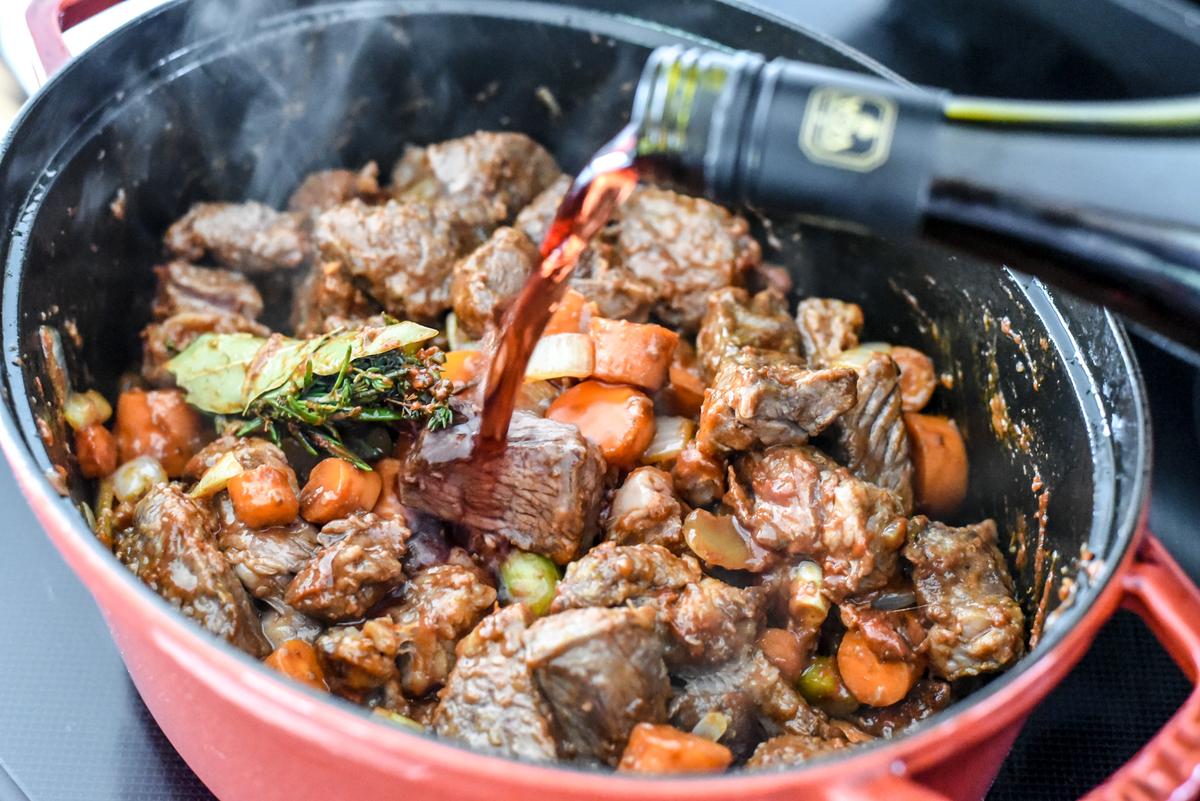 Add the beef, seasonings, and wine to the vegetables, scraping the bottom of the pot to loosen any browned bits. (Audrey Le Goff)