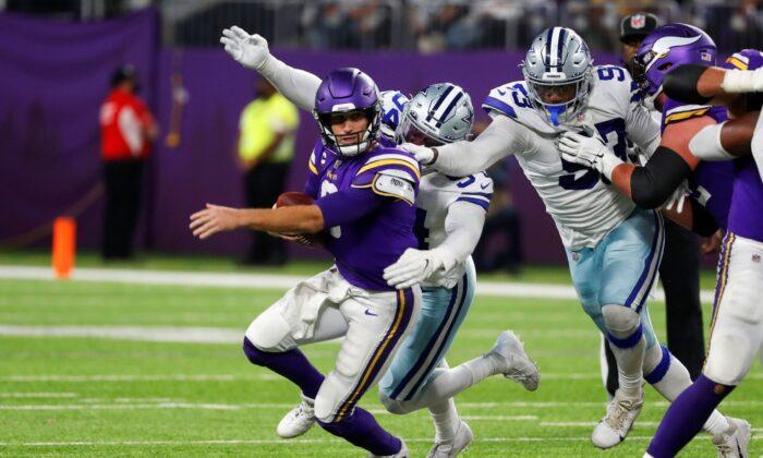 Minnesota Vikings quarterback Kirk Cousins (8) is sacked by Dallas Cowboys defensive end Randy Gregory (94) during the second half of an NFL football game in Minn., on Oct. 31, 2021. (Bruce Kluckhohn/AP Photo)