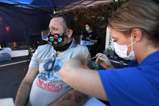 Shaun Fenwick receives the COVID-19 vaccine outside a Bunnings hardware store in Brisbane, Australia, on Oct. 16, 2021. (Dan Peled/Getty Images)