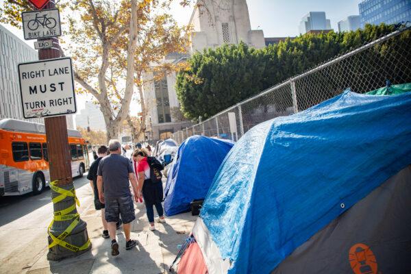 People walk pass a homeless encampment in downtown Los Angeles on Nov. 9, 2021. (John Fredricks/The Epoch Times)