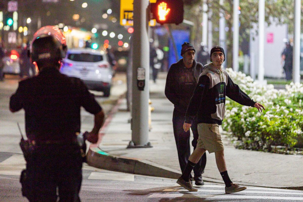 Men taunt a Los Angeles Police Department officer with profanity, on Nov. 6, 2020. (John Fredricks/The Epoch Times)