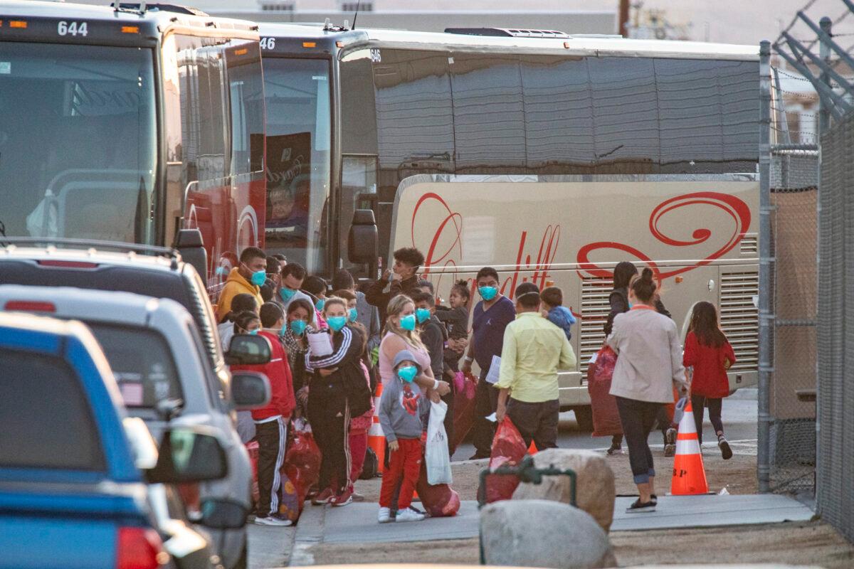 Immigrants are moved onto cater buses and transferred to a migrant shelter in Indio, Calif., on Oct. 18, 2021. (John Fredricks/The Epoch Times)