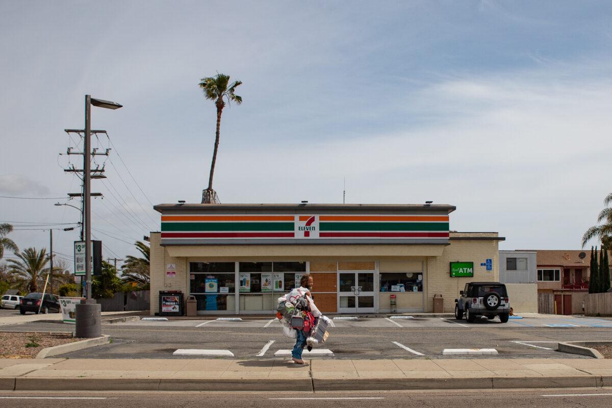 A homeless man walks along Oceanside Blvd. in Oceanside, Calif., on April 14, 2021. (John Fredricks/The Epoch Times)