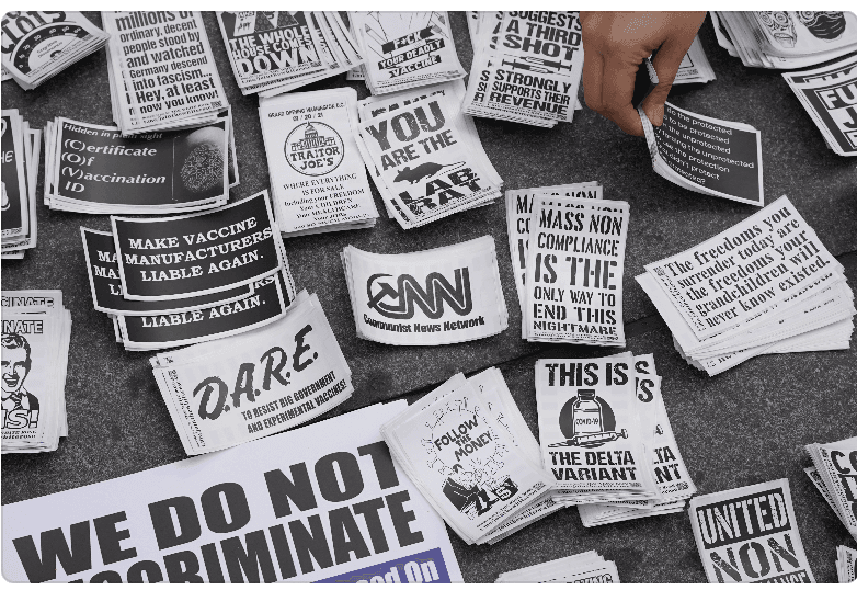 A protester hands out stickers outside New York City Hall on Nov. 3, 2021. (Enrico Trigoso/The Epoch Times)