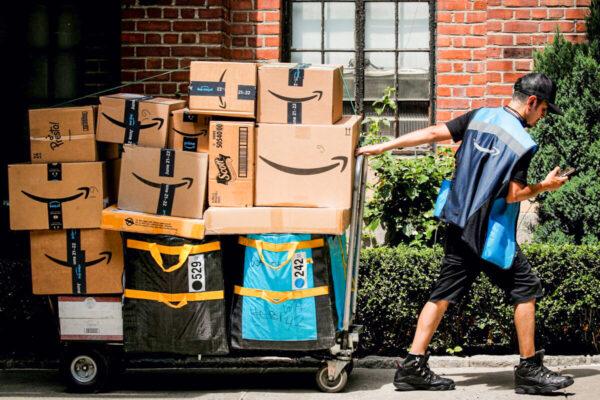 An Amazon delivery worker pulls a delivery cart full of packages in New York City, on June 21, 2021. (Brendan McDermid/Reuters)