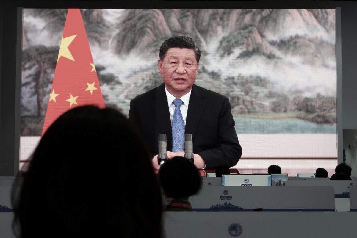 Chinese leader Xi Jinping is seen on television screens at a media center as he delivers a speech via video at the opening ceremony of the China International Import Expo (CIIE) in Shanghai, China, on Nov. 4, 2021. (Andrew Galbraith/Reuters)