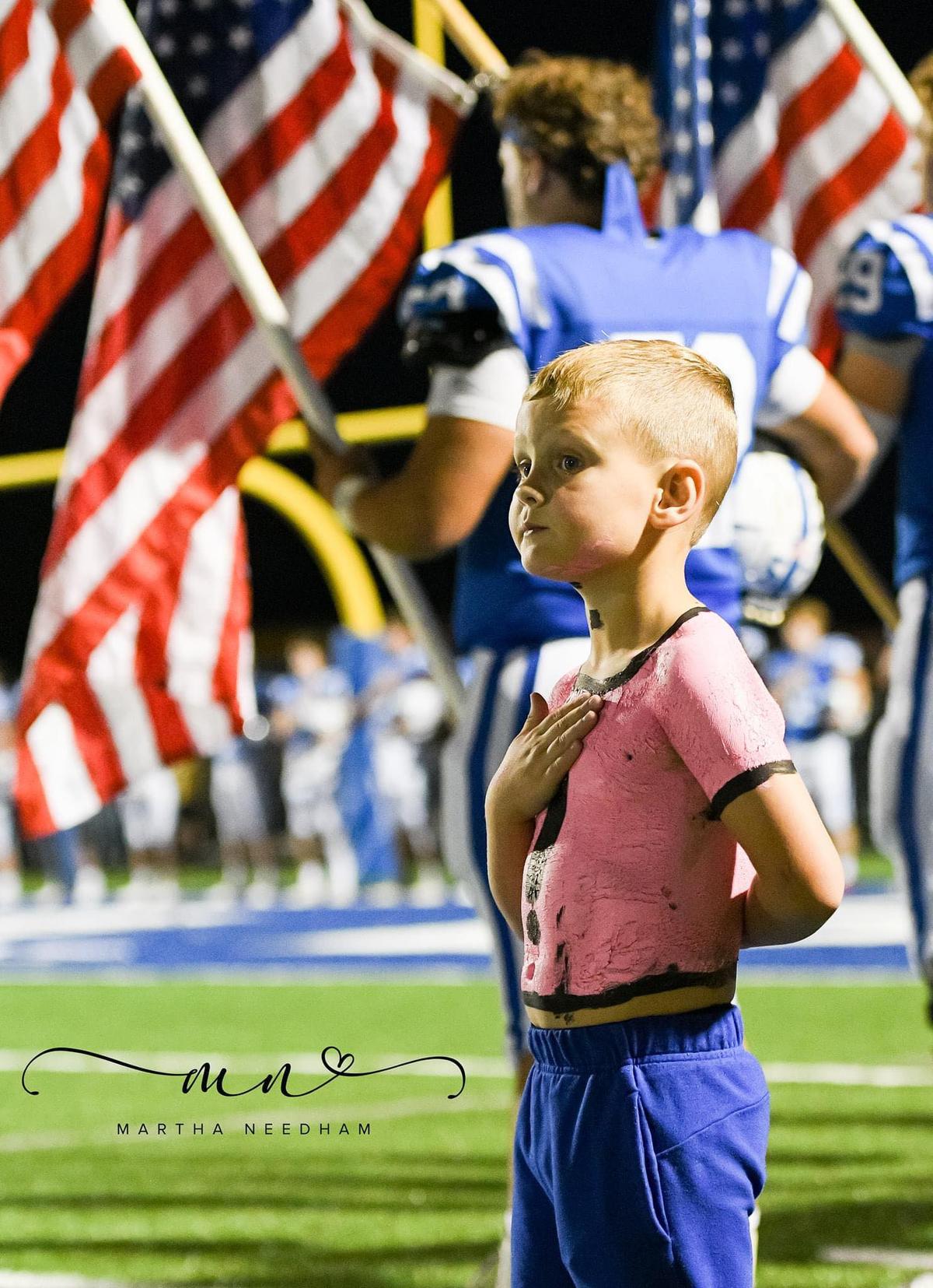 Cooper Routon of Arab, Alabama, was captured saluting the American flag at a local football game. (Courtesy of <a href="https://www.facebook.com/martha.e.needham">Martha Needham</a>)