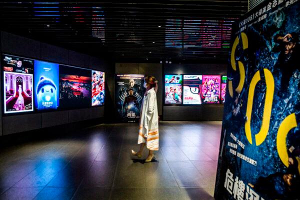 A woman looks at movie advertisements at a cinema in Hong Kong on Sept. 2, 2021. (Isaac Lawrence/AFP via Getty Images)