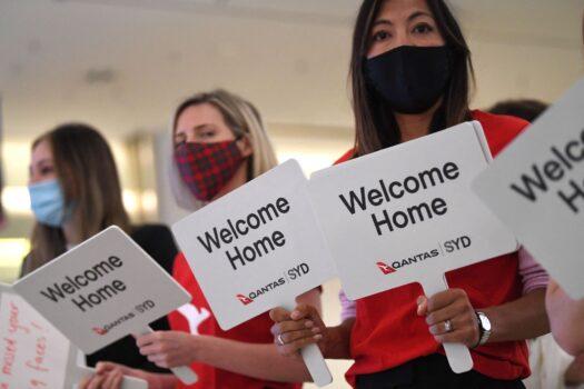 Qantas staff welcome the passengers of Los Angeles flight at the arrival gates of the Sydney International airport after Australia relaxed mandatory quarantine restrictions, on Nov. 1, 2021. (Saeed Khan / AFP via Getty Images)