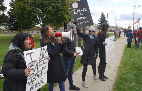 A woman leads a crowd of anti-vaccination mandate protesters in chants and patriotic songs in Royal Oak, Mich., on Nov. 3, 2021. (Steven Kovac/The Epoch Times)