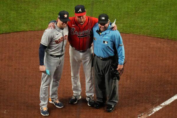 Atlanta Braves manager Brian Snitker (C) poses with his son Houston Astros hitting coach Troy Snitker and home plate umpire Alfonso Marquez before Game 3 of baseball's World Series between the Houston Astros and the Atlanta Braves, in Atlanta on Oct. 29, 2021. (Ashley Landis/AP Photo)